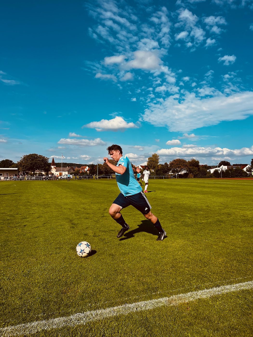 SVN-E-Spieler im hellblauen Trikot treibt den Ball über den Rasen